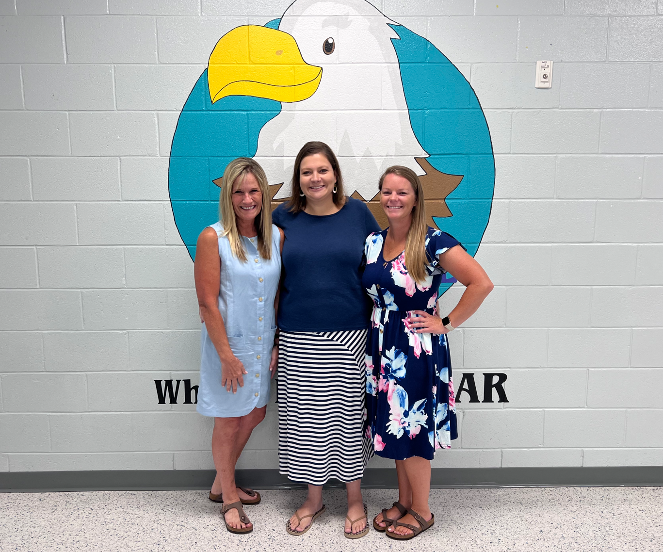 prek teachers standing in front of eagle mural